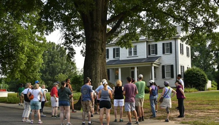 Adults on an tour in front of a house