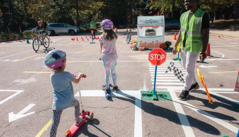 Kids riding scooters and bikes at an Oaks and Spokes Traffic Garden