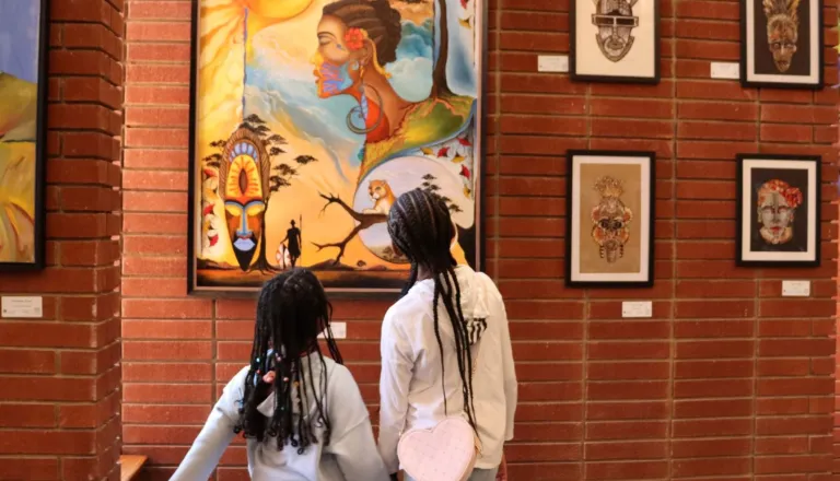 Two girls viewing art in the 2025 Living In Color Exhibit