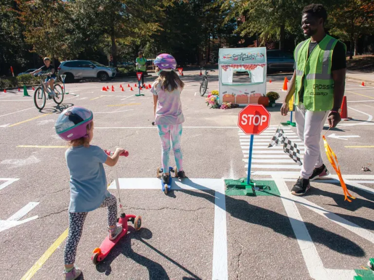 Kids riding scooters and bikes at an Oaks and Spokes Traffic Garden