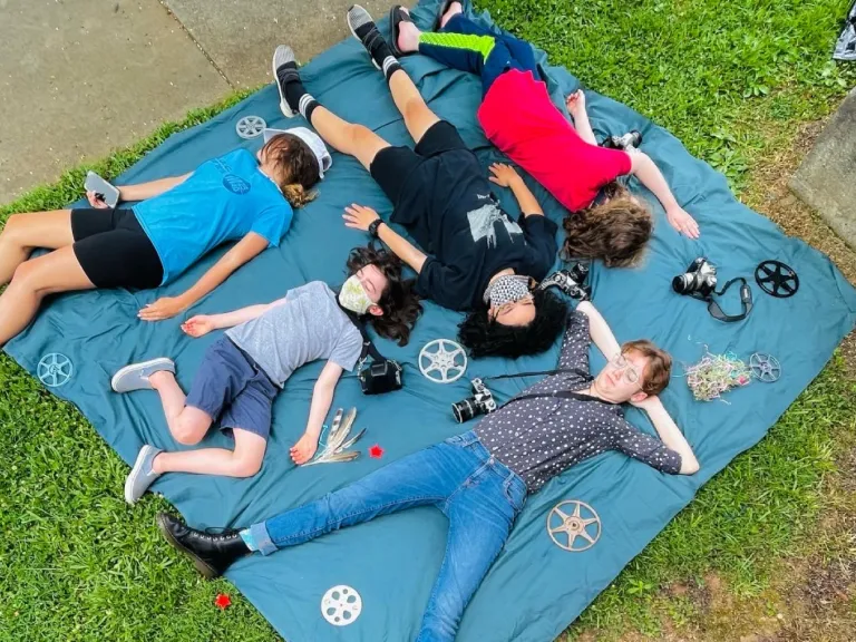 people laying on a piece of fabric