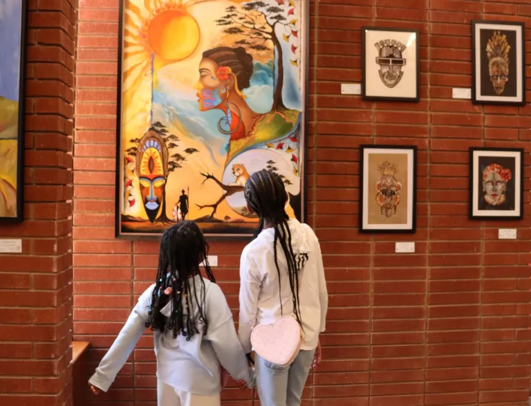 Two girls viewing art in the 2025 Living In Color Exhibit