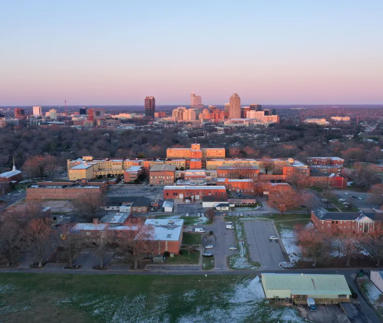 Winter sunset view of downtown Raleigh skyline with Dix Park buildings in the foreground 